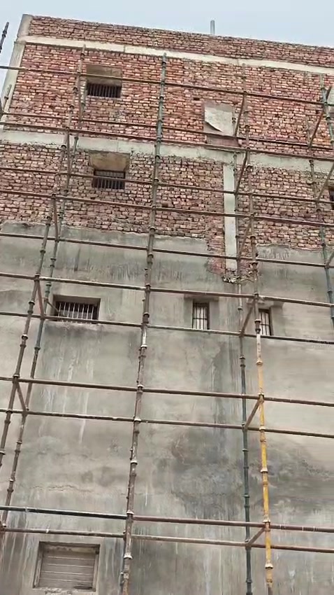 Brick building facade wrapped in scaffolding