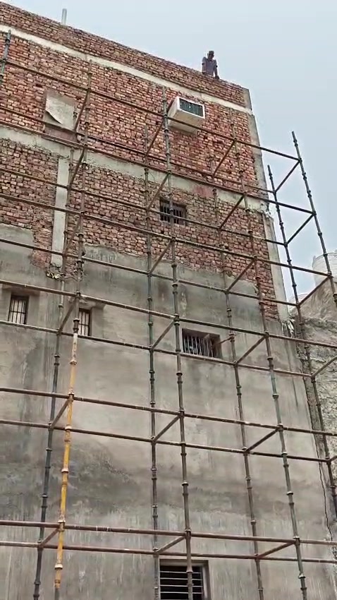 Multi-storey building elevation with full scaffolding coverage